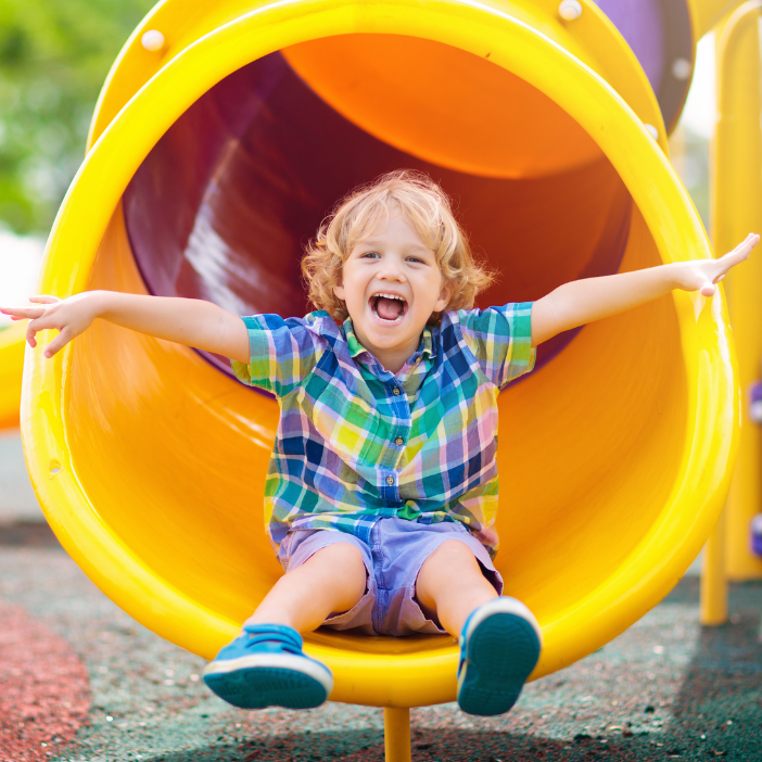 Kid smiling on yellow slide