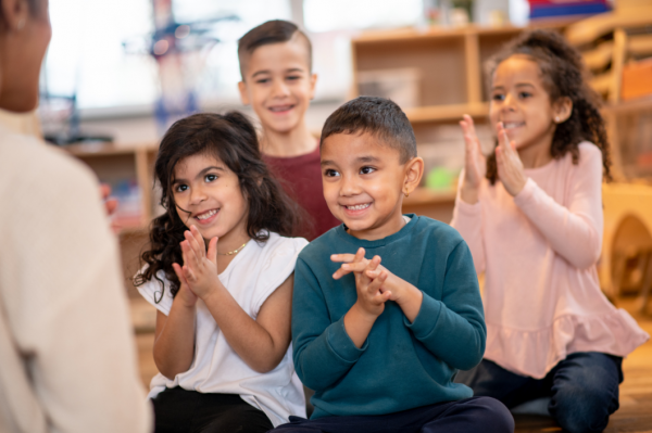 Smiling kids clapping in child care