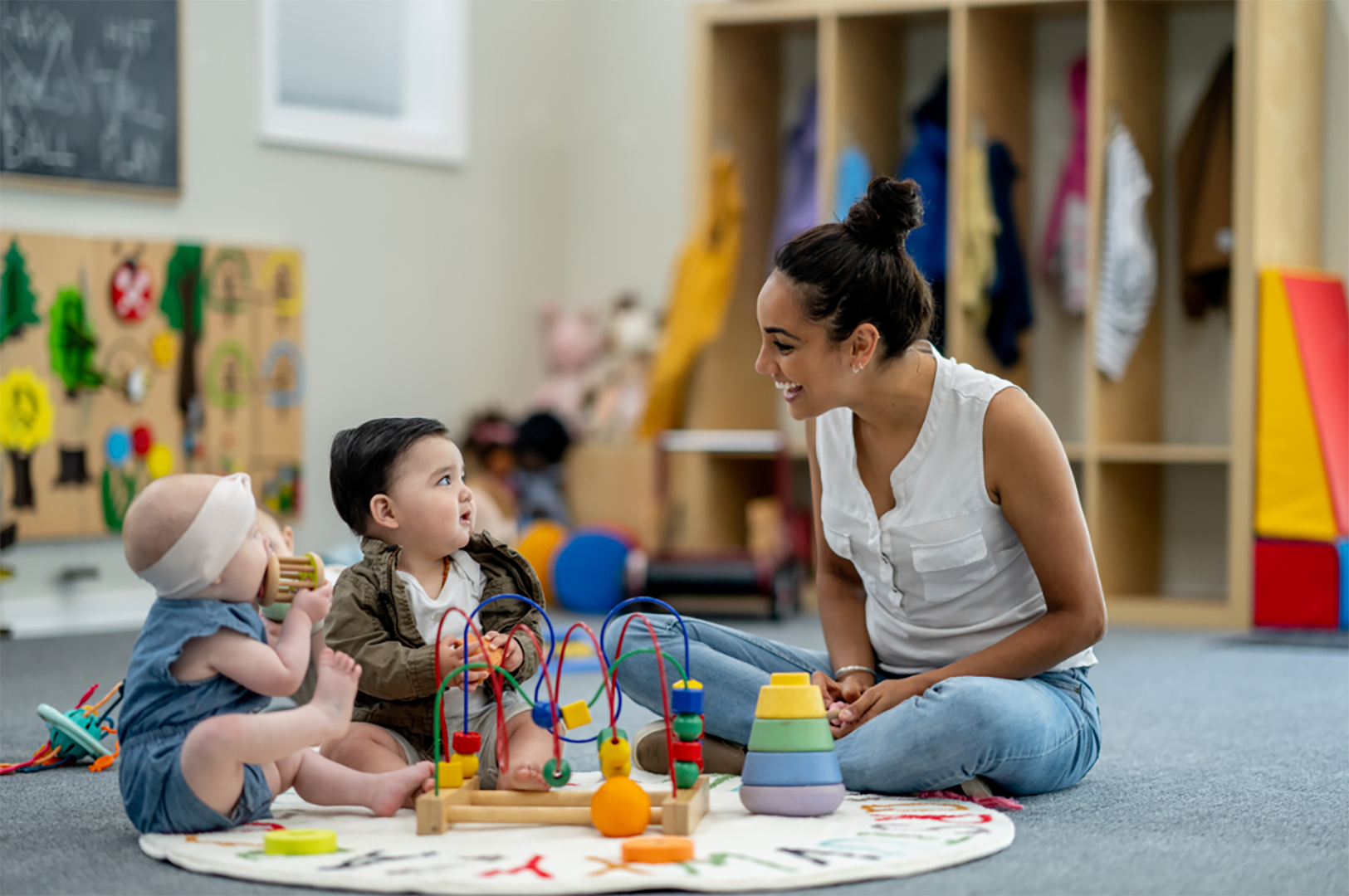 Smiling Teacher With Two Small Children