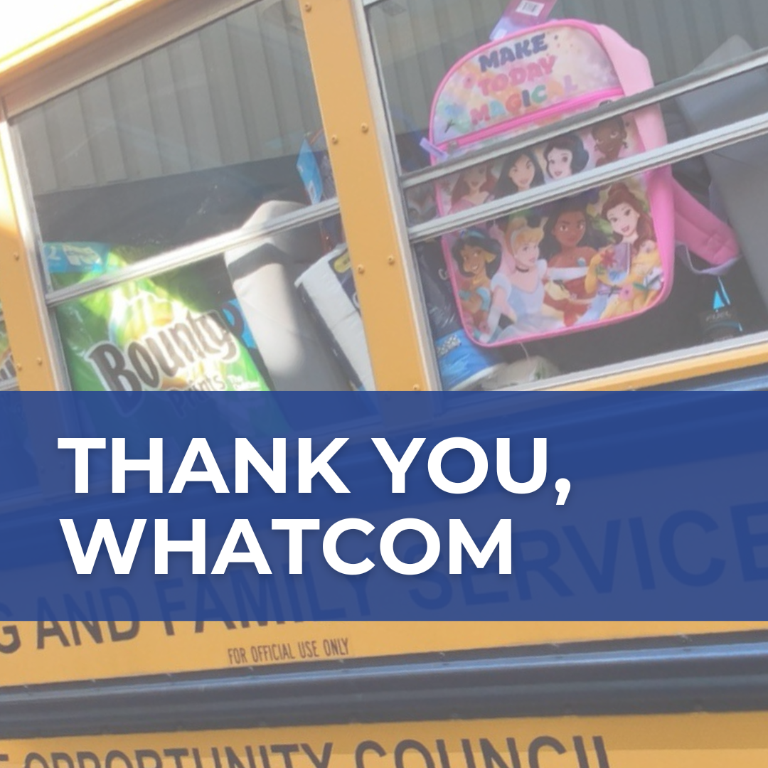 A photo of a yellow school bus filled with items like kids' backpacks and paper towels. A royal-blue banner with white text says "Thank you, Whatcom."