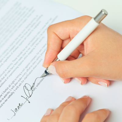 A person signs a piece of paperwork.